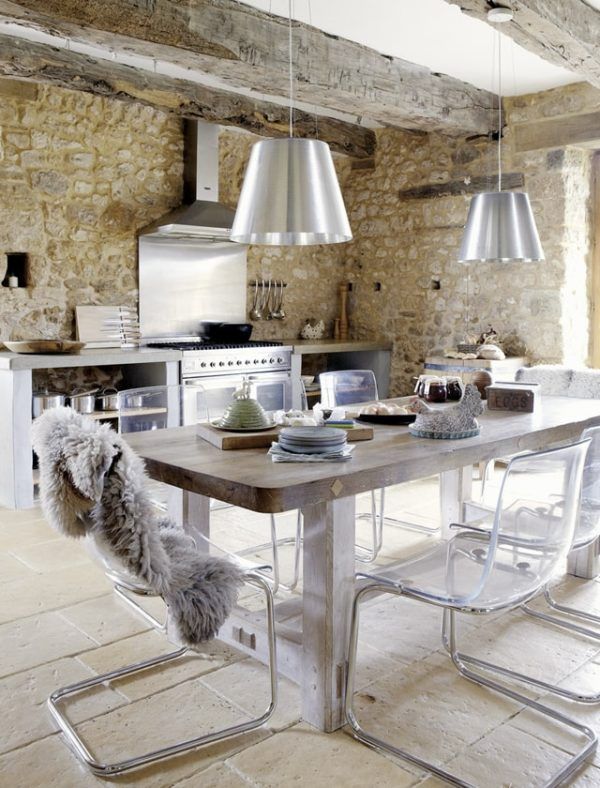 Cocina estilo industrial con lámparas de acero y pared de piedra